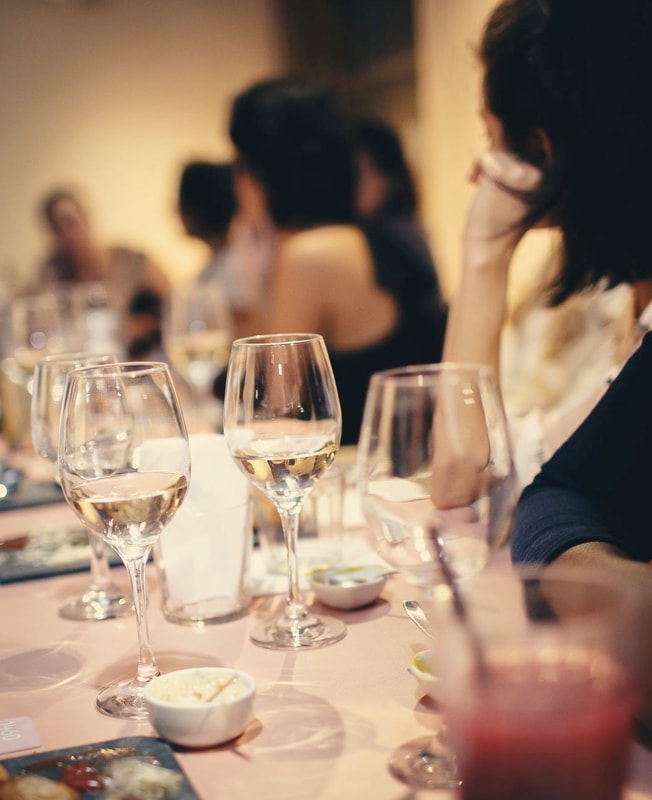 dinner setting with wine glasses and guests seated at a table